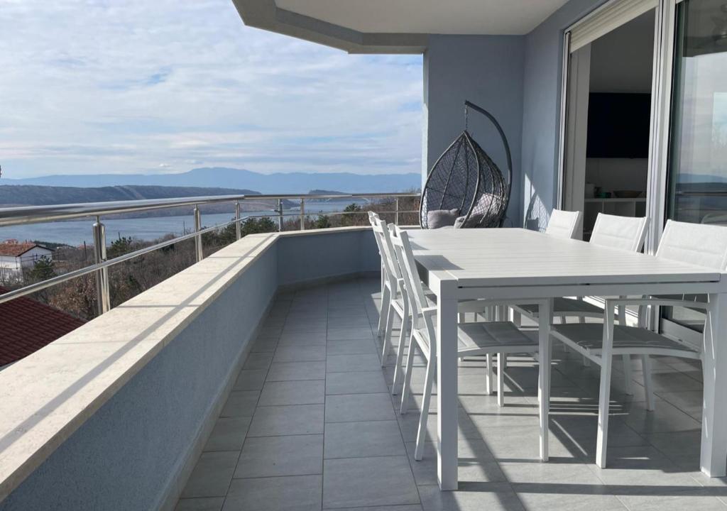 a white table and chairs on a balcony with a view at Anai Jadranovo in Jadranovo