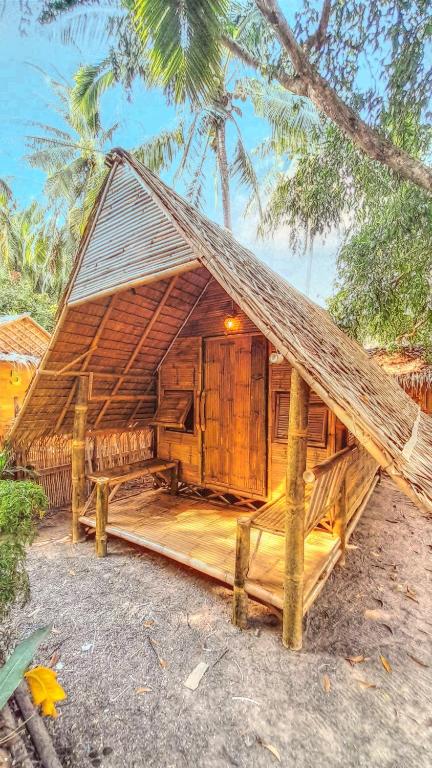 a large wooden house with a thatched roof at Bamboo Village in Ban Tai