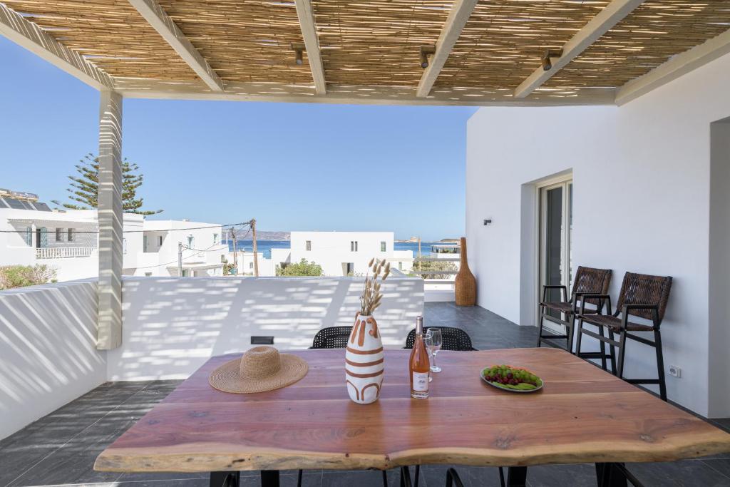 a wooden table on a patio with a view of the ocean at Azimuth Houses in Pollonia