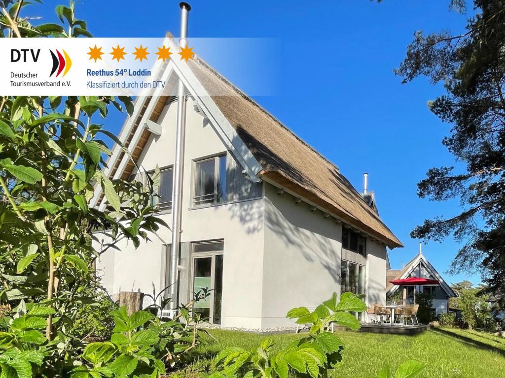 a white house with a thatch roof at Ferienhaus Reethus 54° Loddin in Loddin