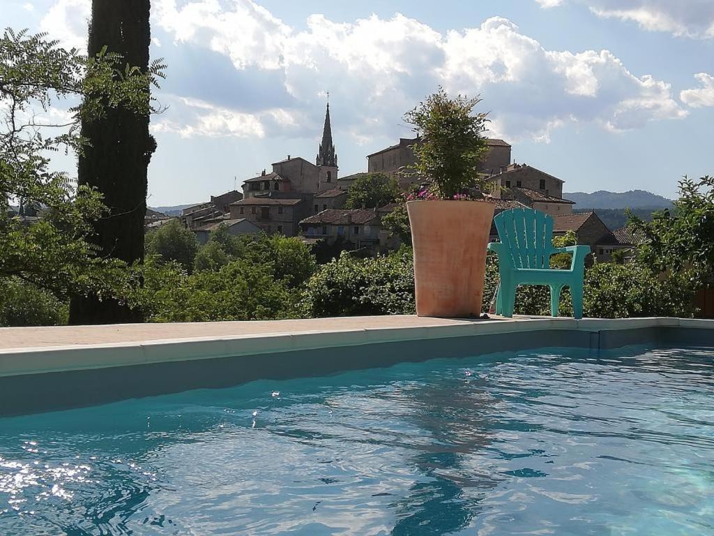 - une piscine avec une chaise bleue installée à côté dans l'établissement La Grangette, à Joyeuse