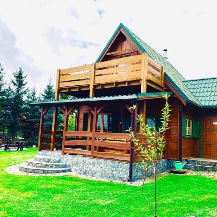 a large wooden house with a green lawn at Letnia Chata u Romana in Zalewo