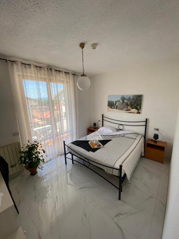 sypialnia z łóżkiem i dużym oknem w obiekcie Hotel Belvedere w mieście Passignano sul Trasimeno