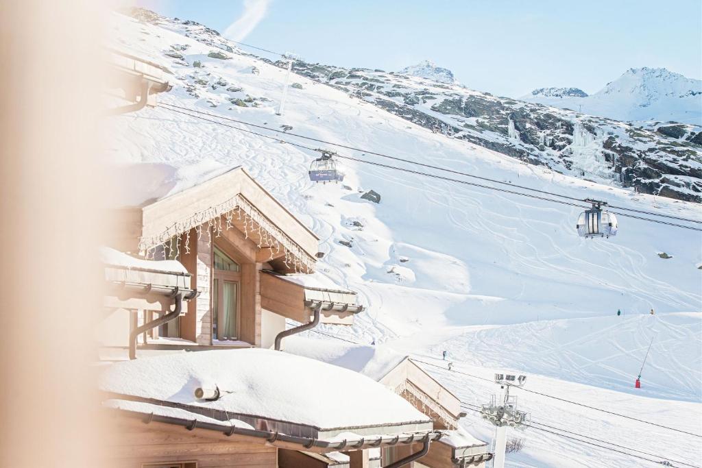 a ski resort with a ski lift in the snow at Hotel Pashmina Le Refuge in Val Thorens