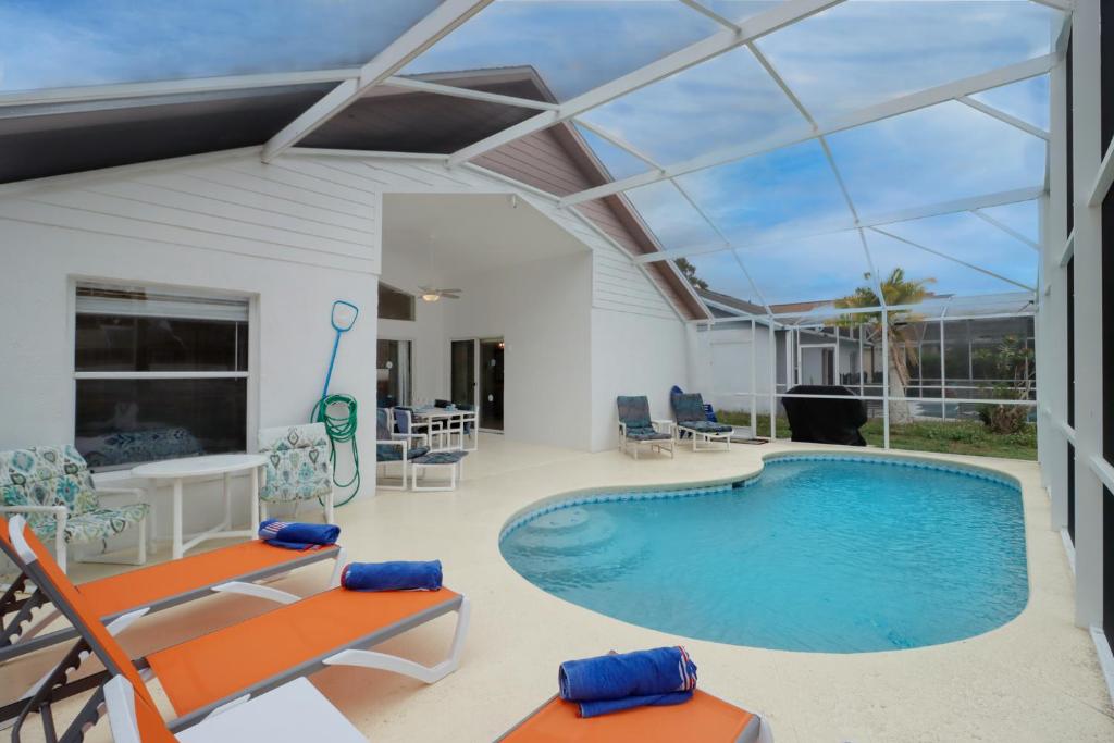 - une piscine dans une maison dotée d'un plafond en verre dans l'établissement Makin Dreams with White Rose Villas - Private Pool - Game Room - Family Friendly - Nr Disney, à Kissimmee