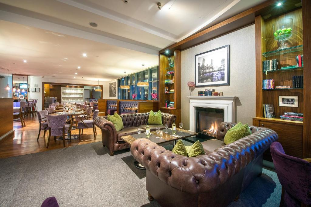 a living room with a couch and a fireplace at Cork International Hotel in Cork
