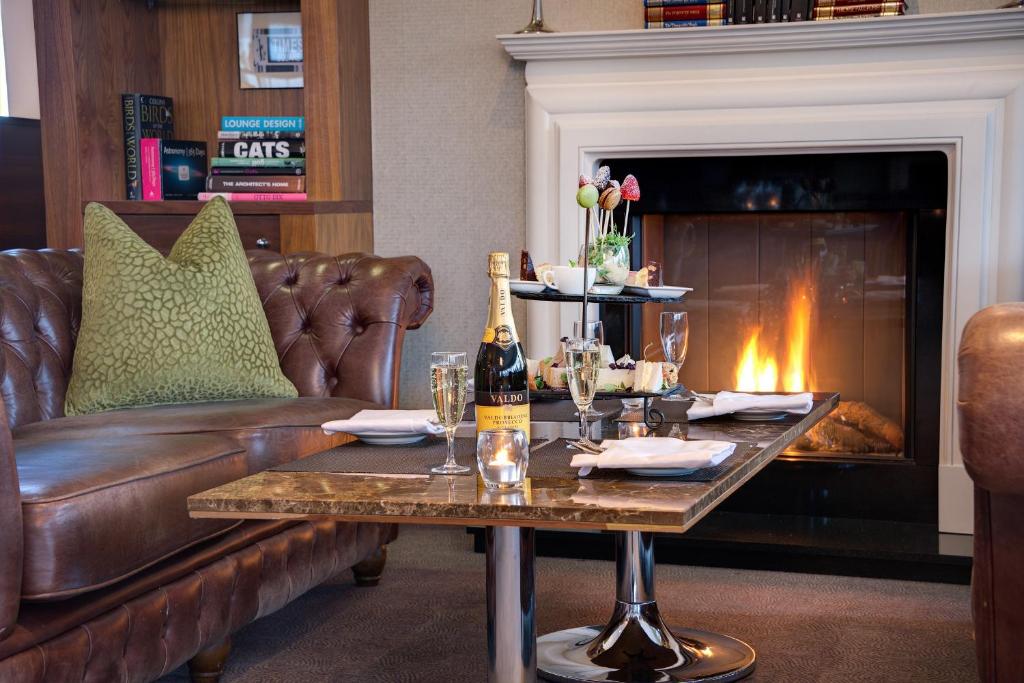 a living room with a couch and a table with a bottle of champagne at Cork International Hotel in Cork