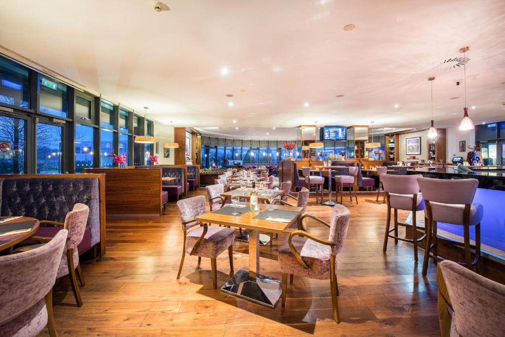 a restaurant with tables and chairs and a bar at Cork International Hotel in Cork
