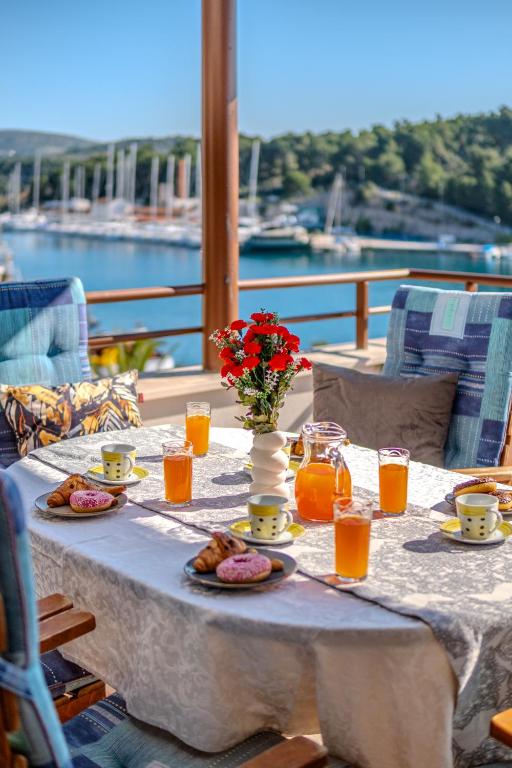 a table with food and orange juice and flowers on it at Moenia Apartments in Milna