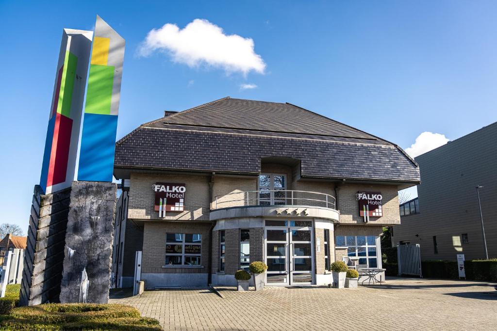 a building with a flag in front of it at Hotel Falko in Meise