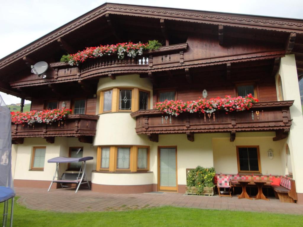 un bâtiment avec des boîtes de fleurs sur les balcons dans l'établissement Ferienhaus Regina, à Tux