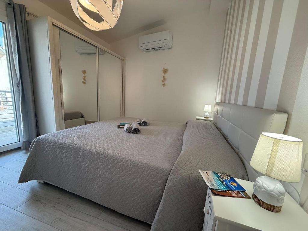 een slaapkamer met een bed en een tafel met een lamp bij Virgilio's House in Tertenìa