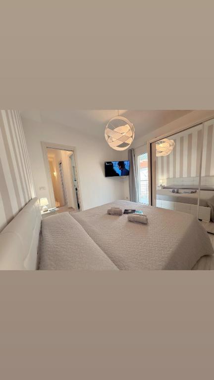 a large white bed in a bedroom with a tv at Virgilio's House in Tertenìa