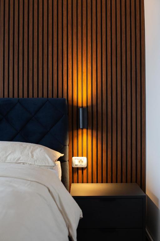 a bedroom with a bed and a wooden wall at Ale Apartament aproape de facultate de medicina Vasile Goldis in Arad