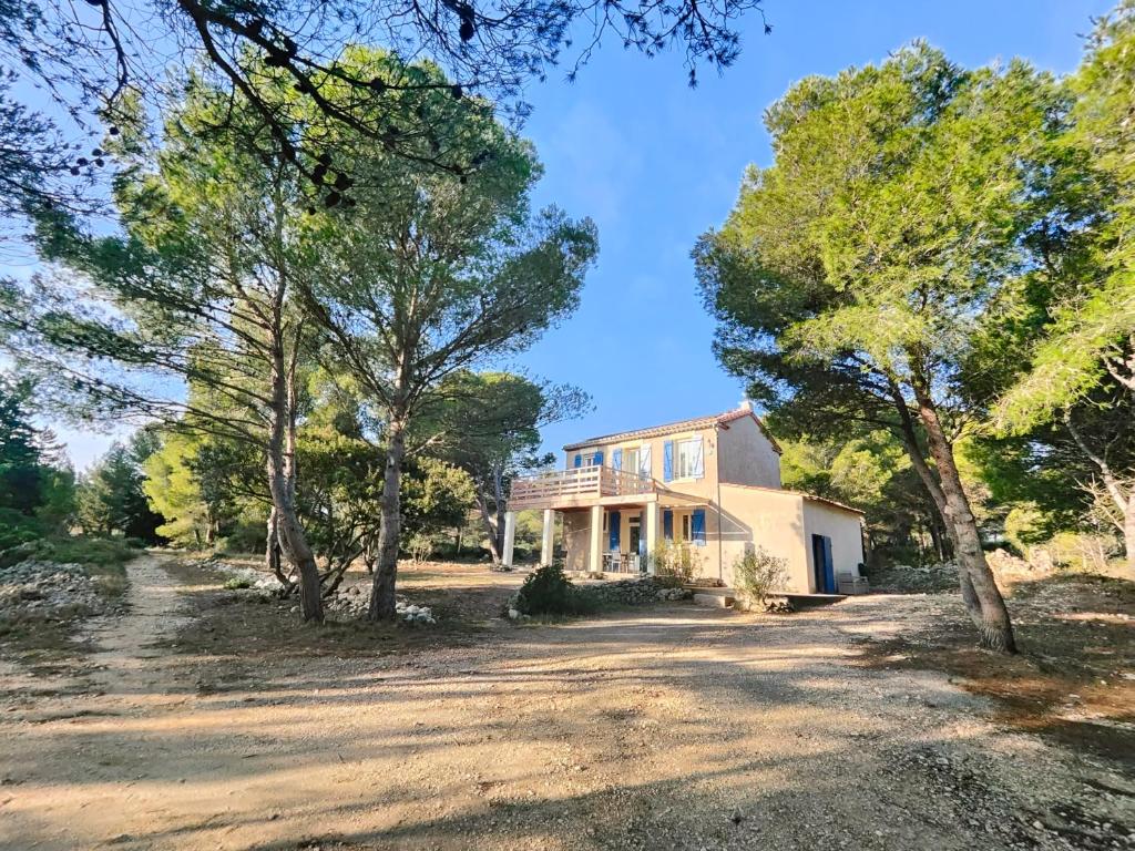 une image d'une maison avec des arbres au premier plan dans l'établissement Mas de Caussagues, la Presqu'ile, à Sigean