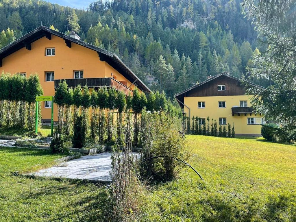 a house in the middle of a field with trees at Ferienwohnung Königspudel in Nauders