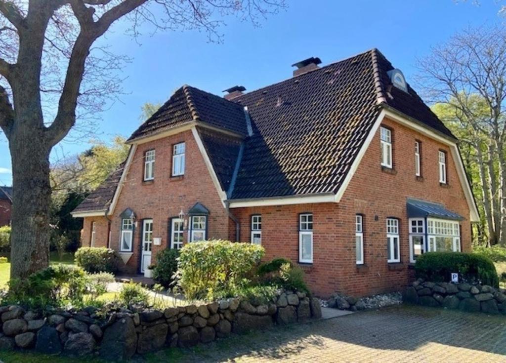 a brick house with a shingled roof at Schwalbennest in Wyk auf Föhr