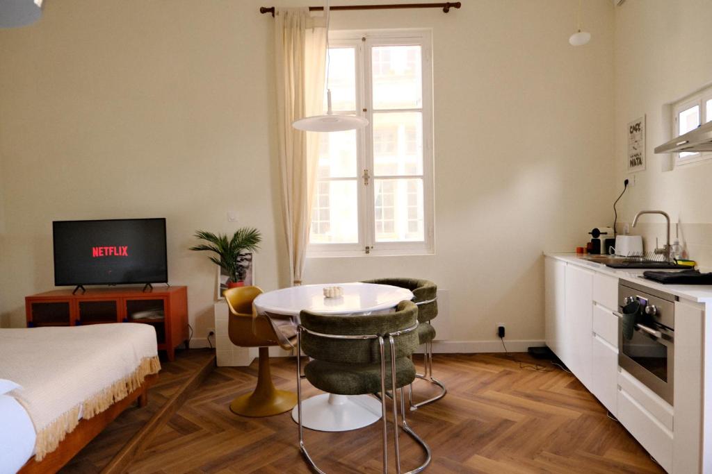 une chambre avec un lit et une table et une cuisine dans l'établissement CASA DOM ARMANDO - Climatisation & Parking, à Montpellier