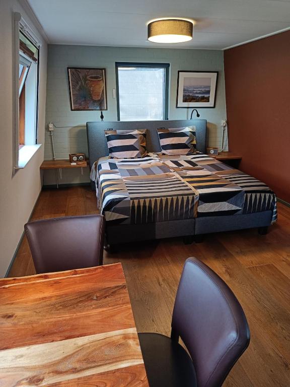 a bedroom with a bed and a table and chairs at KNUS tiny gardenhouse in Doorn