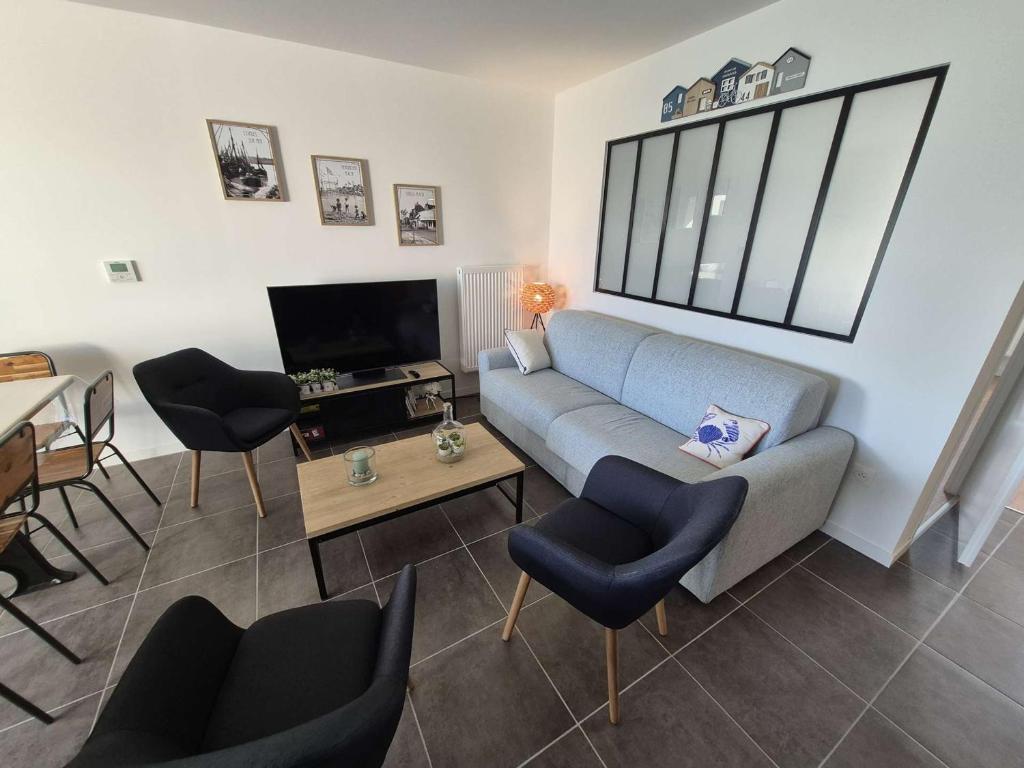 un salon avec un canapé, des chaises et une télévision dans l'établissement Appartement 3 chambres à Stella-plage avec parking et animaux admis - FR-1-236-163, à Cucq