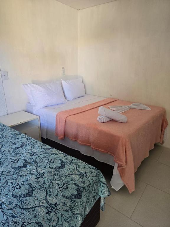 two beds in a hotel room with towels on them at Quarto quádruplo in Conde