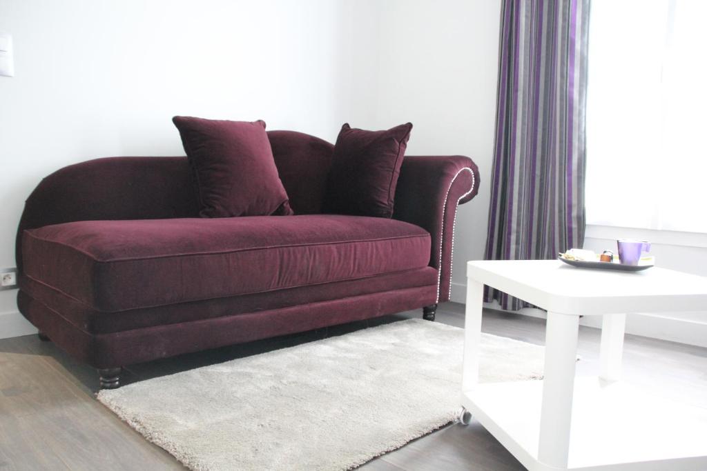- un salon avec un canapé violet et une table blanche dans l'établissement Cosy Apparts Suresnes La Défense, à Suresnes