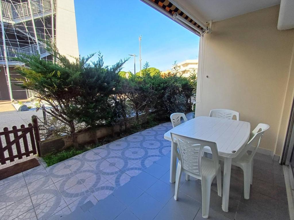 une table blanche et des chaises sur une terrasse dans l'établissement Charmant F2 avec terrasse près de l'Étang de Thau, équipé pour 4 pers. et proche établissement thermal - FR-1-571-41, à Balaruc-les-Bains