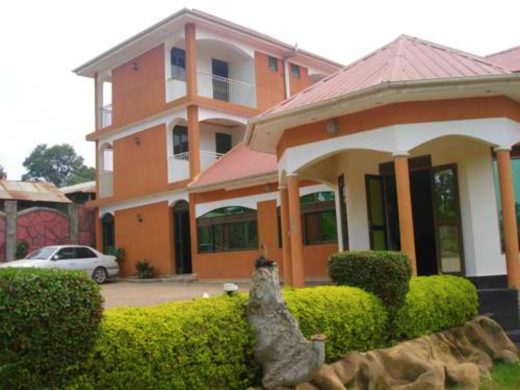 ein großes Haus mit einem davor geparkt in der Unterkunft Rays Hotel in Mbarara