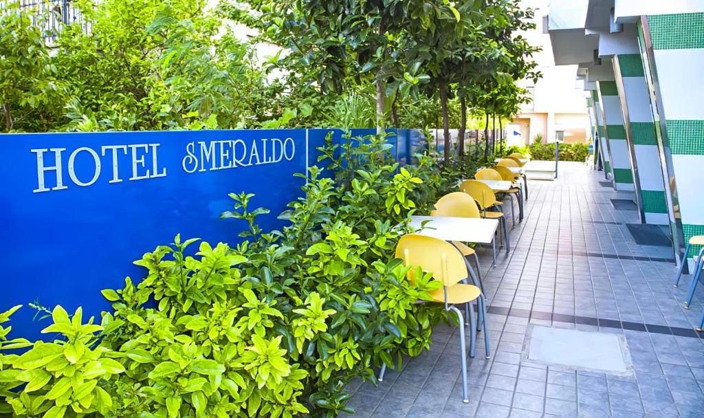 una fila di tavoli e sedie di fronte a un edificio di Hotel Smeraldo a Tortoreto