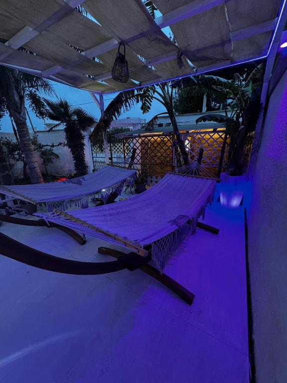 two empty beds in a room with purple lights at Villa Immacolata in Casalabate