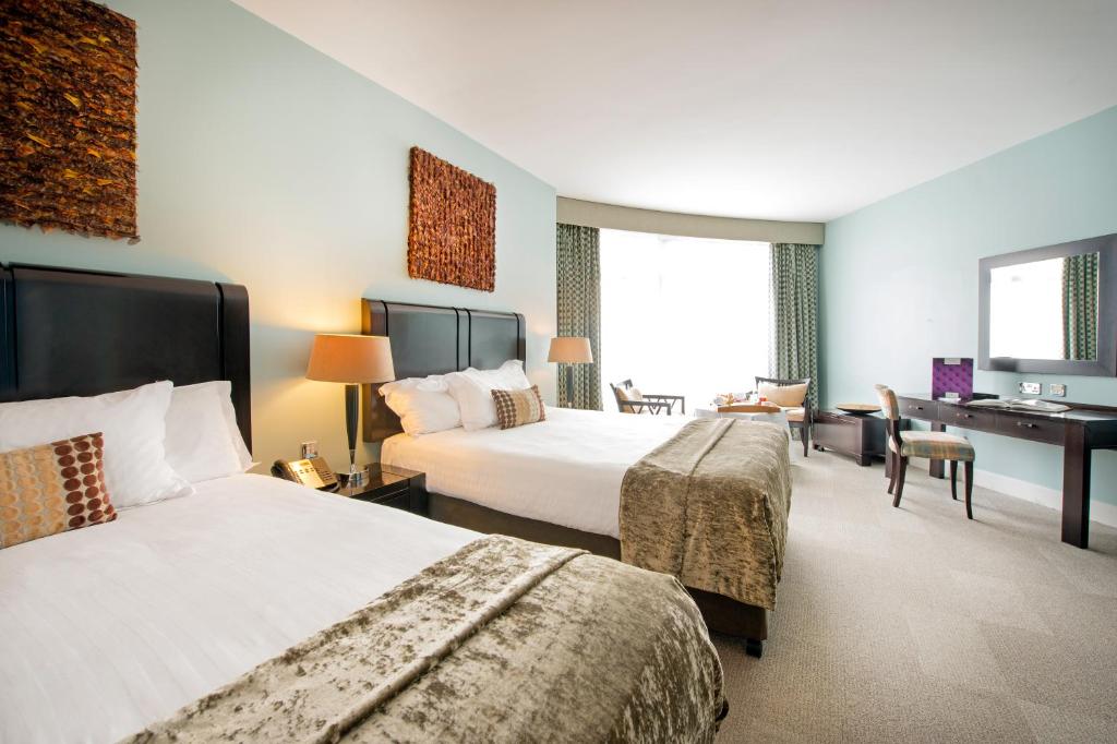 a hotel room with two beds and a desk at Cork International Hotel in Cork