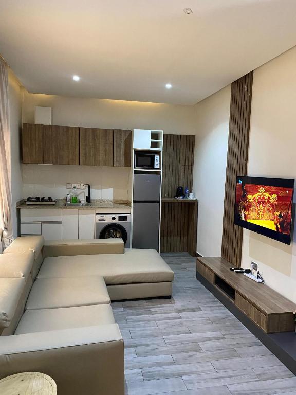 a living room with a couch and a flat screen tv at Centurion Aparthotel in Abuja