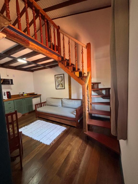 a living room with a couch and a staircase at Studio Hashi 04 in Paraty