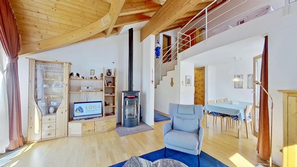 a living room with a blue chair and a table at Lejin 18 in Silvaplana
