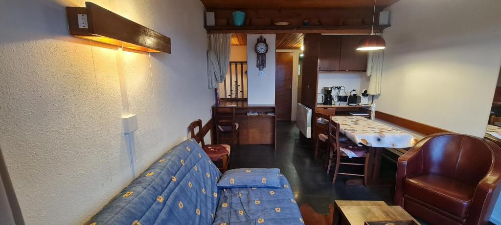 un salon avec un canapé bleu et une table dans l'établissement Murat-le-Quaire Appartement meublé classé 2 étoiles, à Murat-le-Quaire