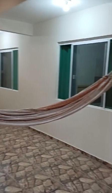 - un hamac dans une chambre avec 2 fenêtres dans l'établissement Casa Fundos na Enseada - 2 Quartos, à São Francisco do Sul