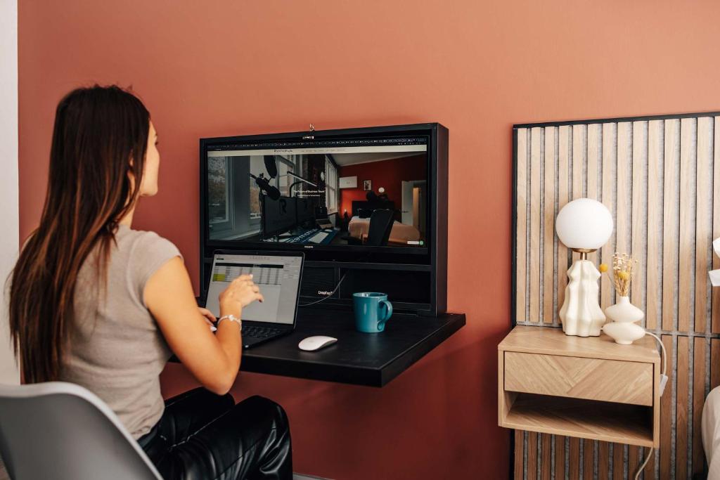 a woman sitting at a desk with a laptop at Studio 2 - Gorgeous studio in Earls Court in London