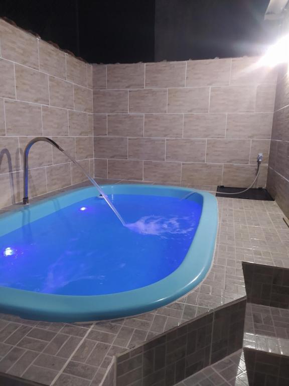a large blue bath tub with a water hose at Casa com piscina Mongaguá 2 quartos in Mongaguá