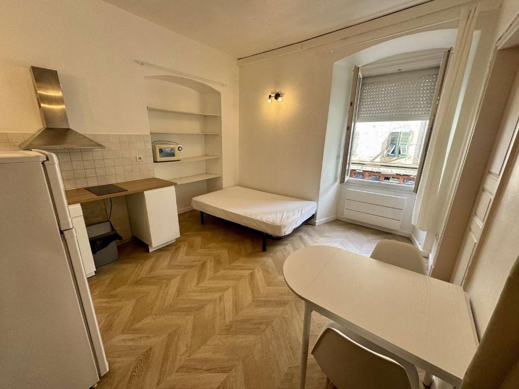 une petite cuisine avec une petite table et une fenêtre dans l'établissement Charmant studio cours Paoli, à Corte