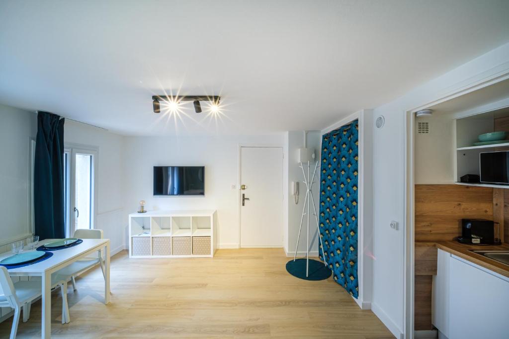 une cuisine et un salon avec une table et une salle à manger dans l'établissement L'Atelier Lobau Nancy - Studio Élégant en Centre-Ville, à Nancy