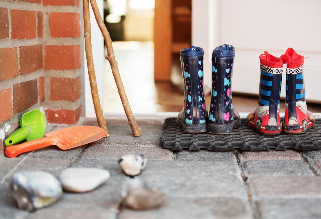 eine Gruppe von Gummistiefeln, die neben einer Wand sitzen in der Unterkunft Bauernhof Höper-Rauert - Reihenhaus 2 in Neujellingsdorf
