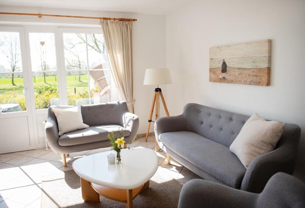 ein Wohnzimmer mit Sofa, Stühlen und einem Tisch in der Unterkunft Bauernhof Höper-Rauert - Reihenhaus 7 in Neujellingsdorf