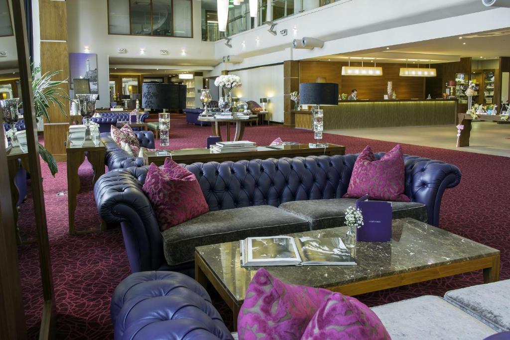 a lobby with couches and tables in a building at Cork International Hotel in Cork