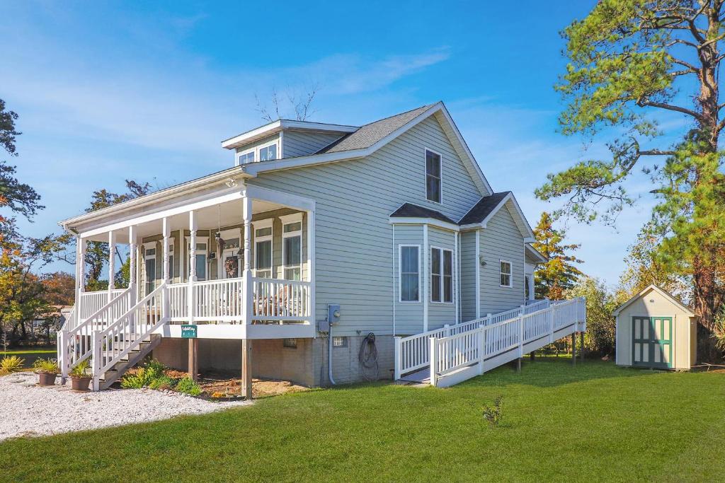 a blue house with a porch and a large yard at Cockleshell Cottage - Pet friendly & Handicap Accessible! in Deep Hole