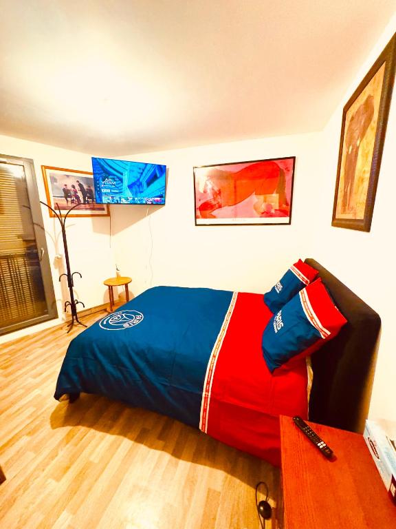 - une chambre avec un lit doté d'une couette rouge et bleue dans l'établissement Jolie chambre à Nanterre Préfecture proche La Défense Aréna Campus SNCF et Paris, à Nanterre