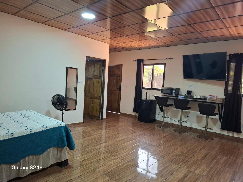 a room with a table and a television on the wall at Pleasant Hostal Panama in Aserrío