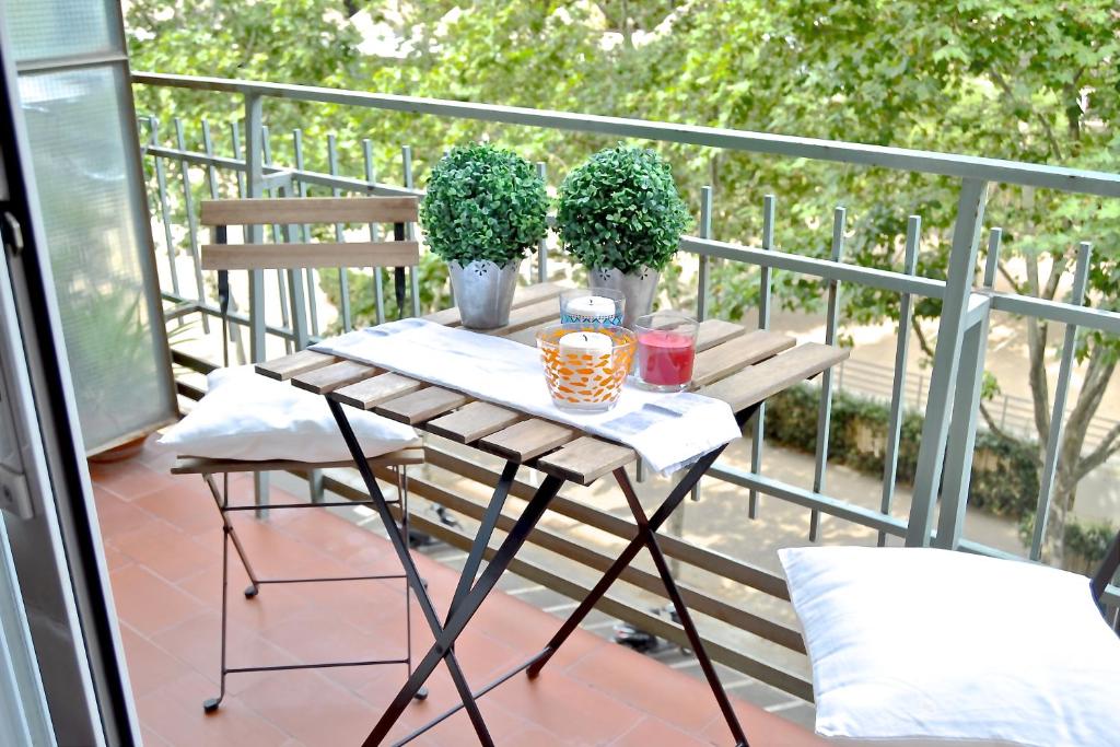 a small table on a balcony with two plants at Auditori Barcelona in Barcelona