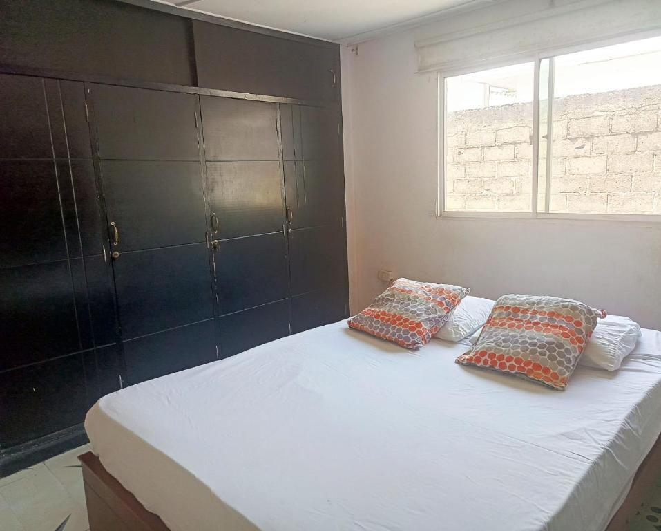 Un dormitorio con una cama con dos almohadas encima. en Casa Beatriz Barranquilla, en Barranquilla
