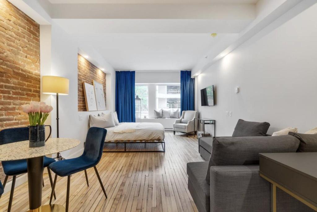 un salon avec un canapé et un lit dans l'établissement Initial / Suite trésor / Centre-Ville de Québec, à Québec