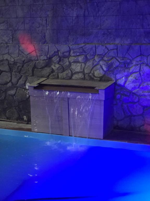 a stone wall with a box in the water at Quarto duplo ventilador in Conde